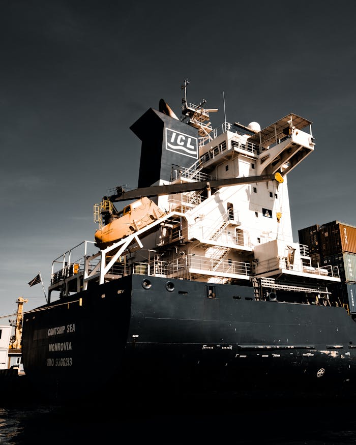 Large cargo vessel docked at Istanbul harbor under dramatic skies, showcasing global trade.